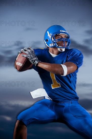 Mixed race football player preparing to throw football