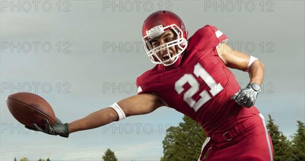 Black football player catching football