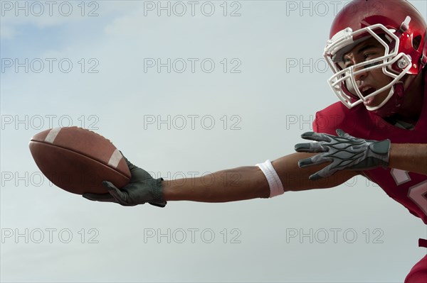 Black football player catching football