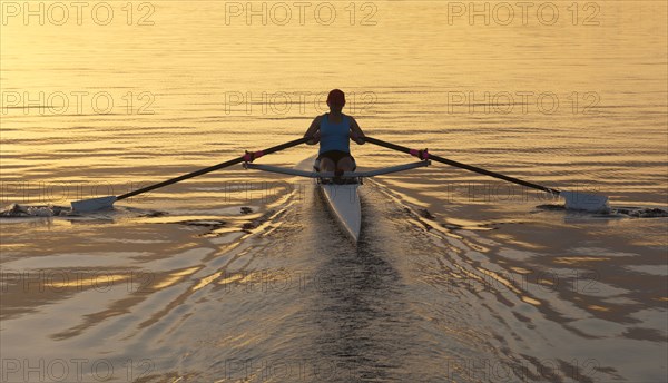 Person rowing sculling boat on river