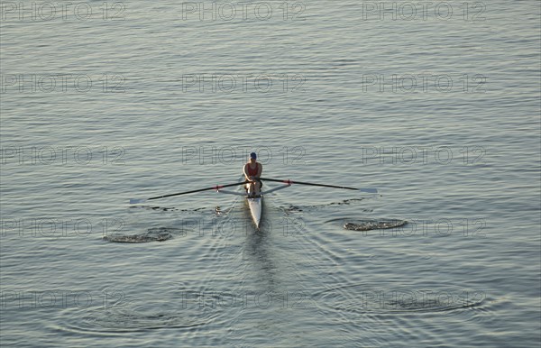 Person rowing sculling boat on river