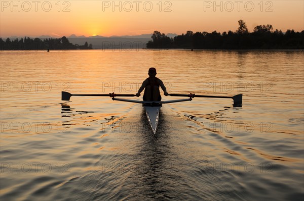 Person rowing sculling boat on river