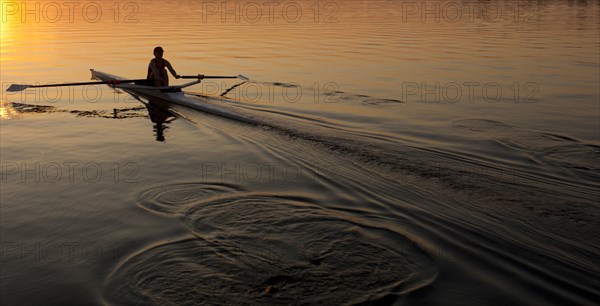 Person rowing sculling boat on river