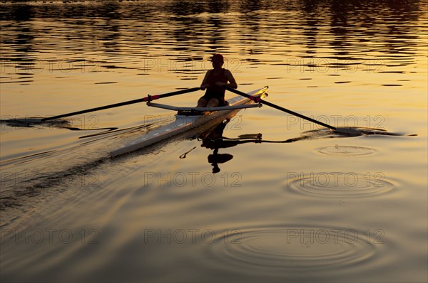 Person rowing sculling boat on river