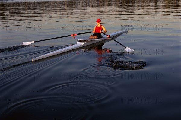 Person rowing sculling boat on river