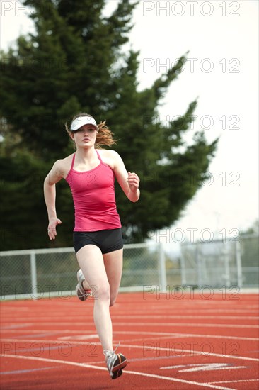 Mixed race teenager running on track