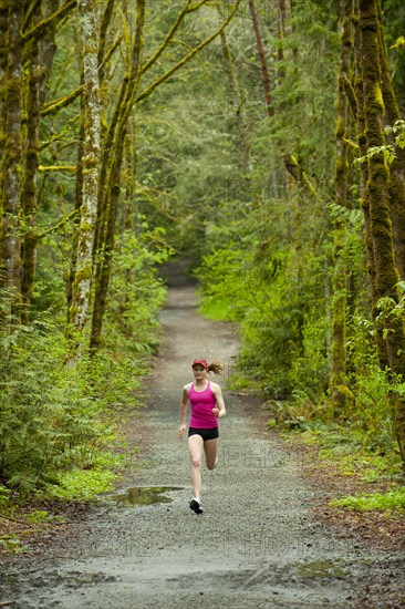 Mixed race woman running on remote path