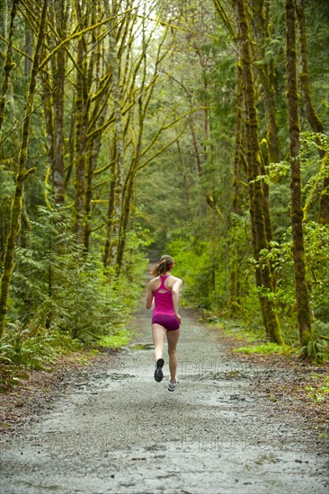 Mixed race woman running on remote path