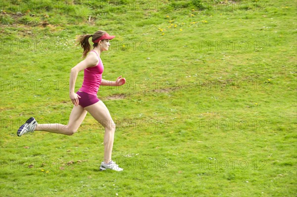 Mixed race woman running in field