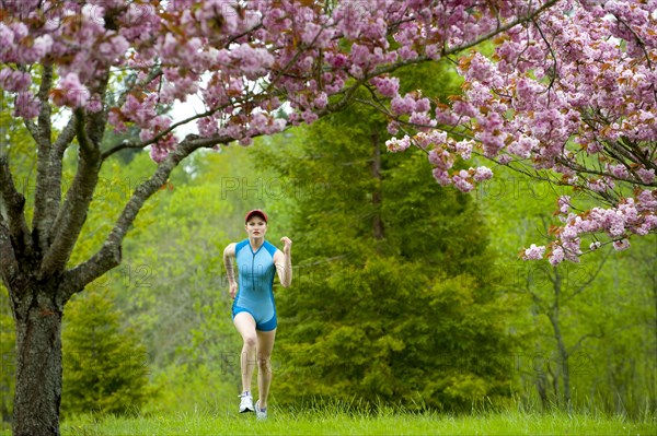 Mixed race runner jogging across grass