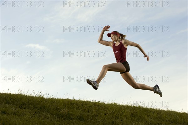 Caucasian runner running in field