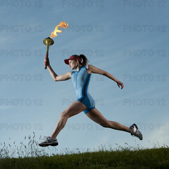 Caucasian athlete running with Olympic torch