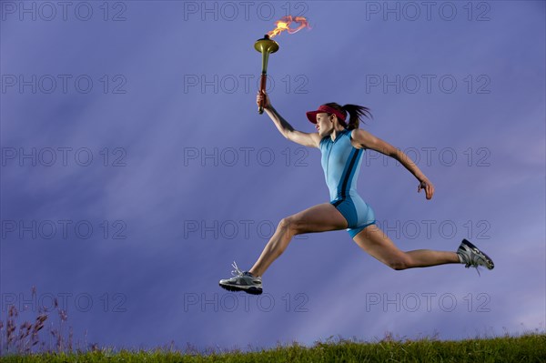Caucasian athlete running with Olympic torch
