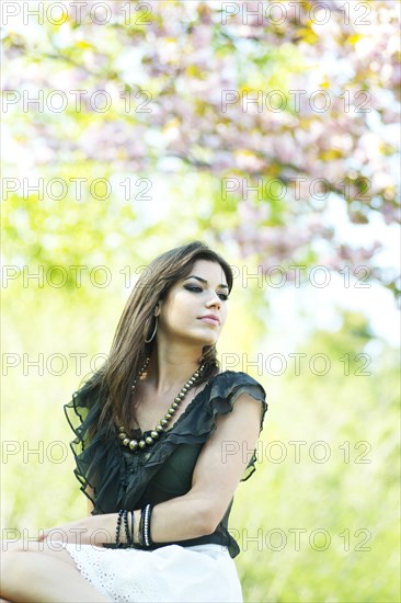 Glamorous Caucasian woman sitting outdoors