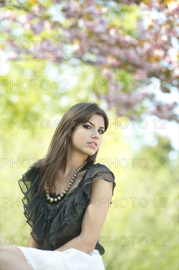 Glamorous Caucasian woman sitting outdoors