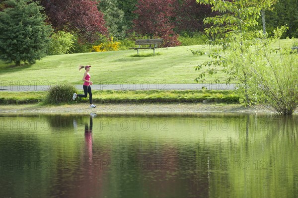 Jogger running near park pond