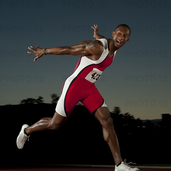 Black runner crossing finish line in race