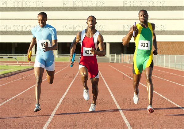 Runners running on track in relay race