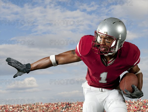 Black football player holding football