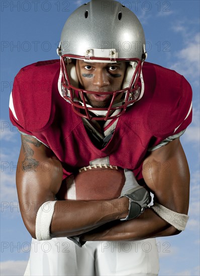 Black football player holding football