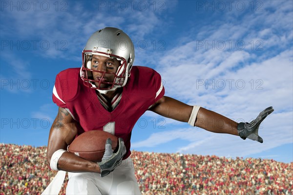 Black football player holding football