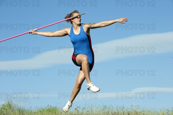 Caucasian athlete throwing javelin