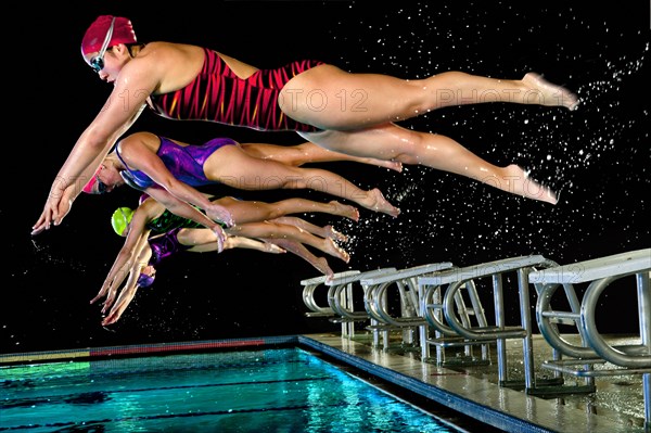 Swimmers diving off starting blocks