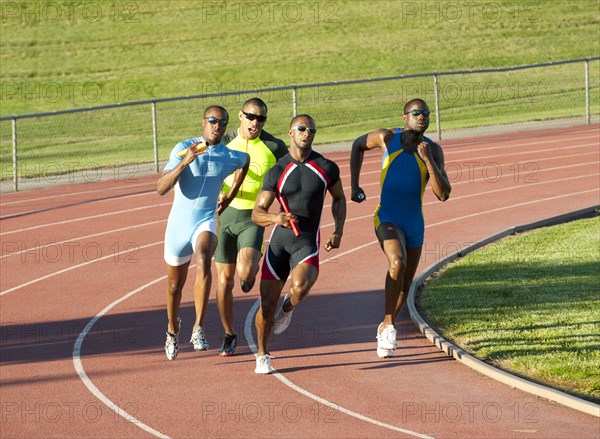 Relay racers running on track in race