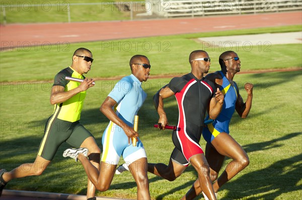 Relay racers running on track in race