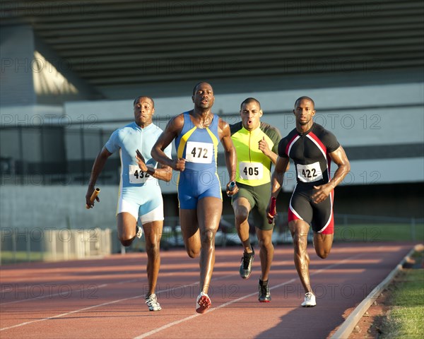 Relay racers running on track in race