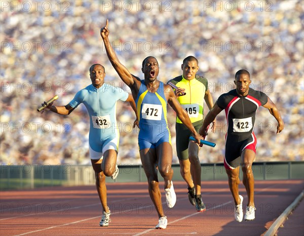 Relay racer crossing finish line on track in race