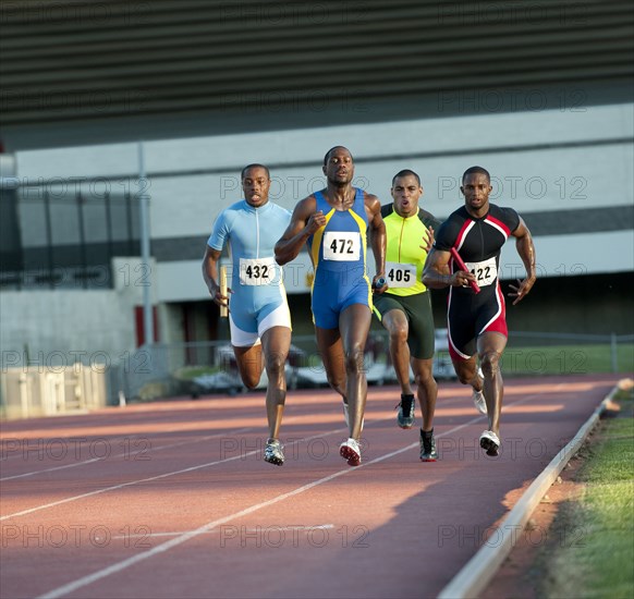 Relay racers running on track in race