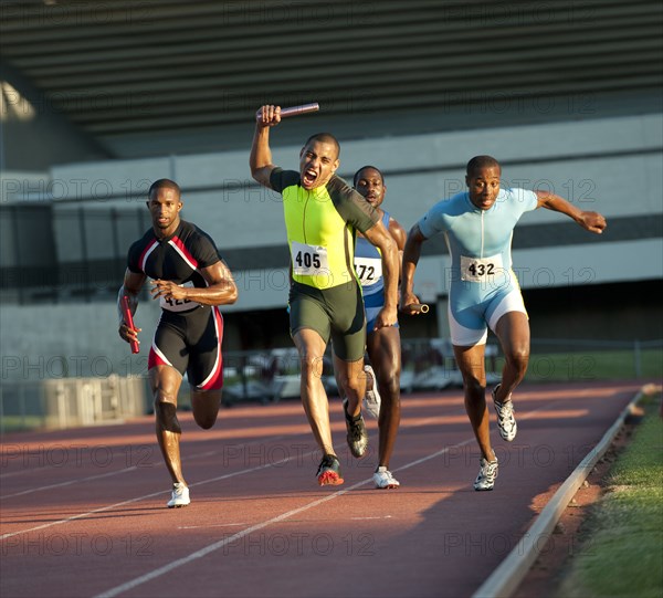 Relay racer crossing finish line on track in race