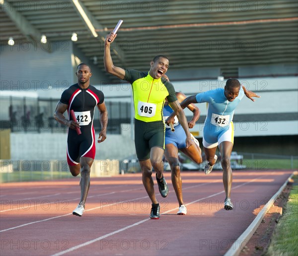 Relay racer crossing finish line on track in race