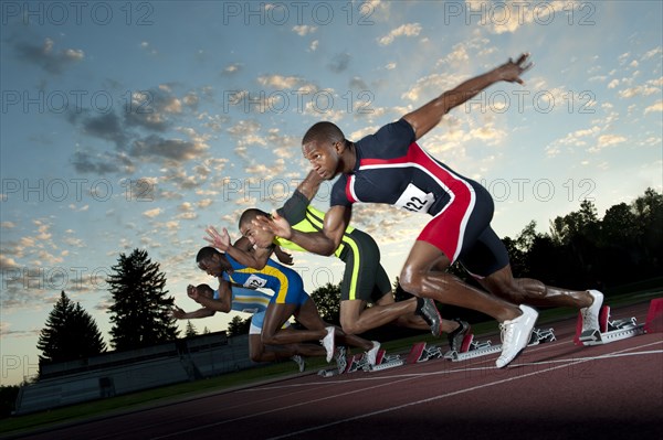 Runners starting on track from starting blocks