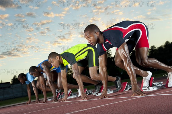 Runners preparing for race at starting blocks