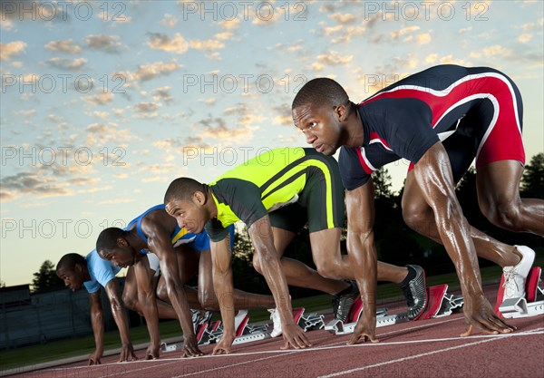 Runners preparing for race at starting blocks