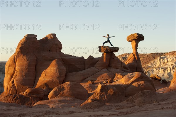 Caucasian woman practicing yoga on top of rock formation