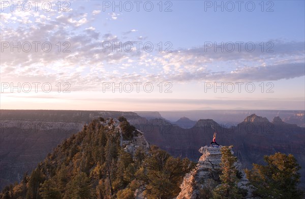 Caucasian woman practicing yoga on top of rock formation