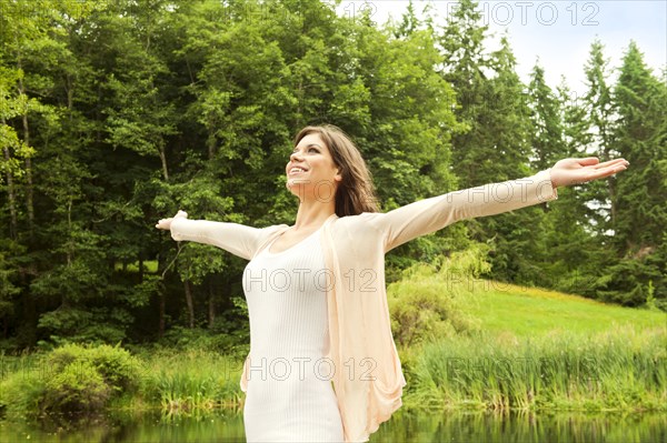 Caucasian woman standing outdoors with arms outstretched