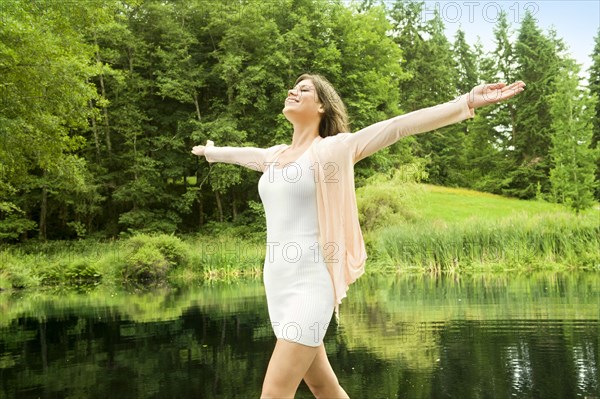 Caucasian woman standing outdoors with arms outstretched