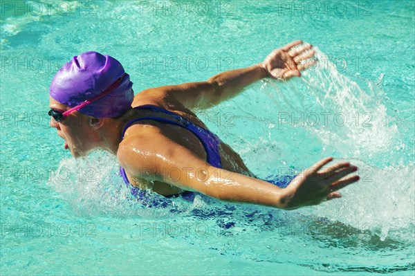 Caucasian teenager swimming in swimming pool