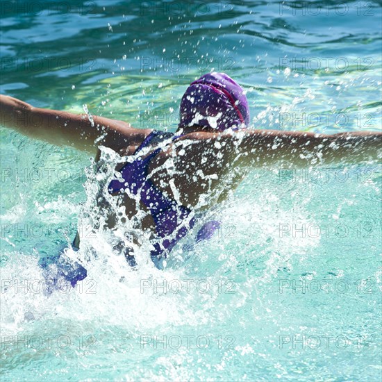 Caucasian teenager swimming in swimming pool