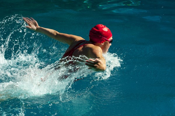 Caucasian teenager swimming in swimming pool