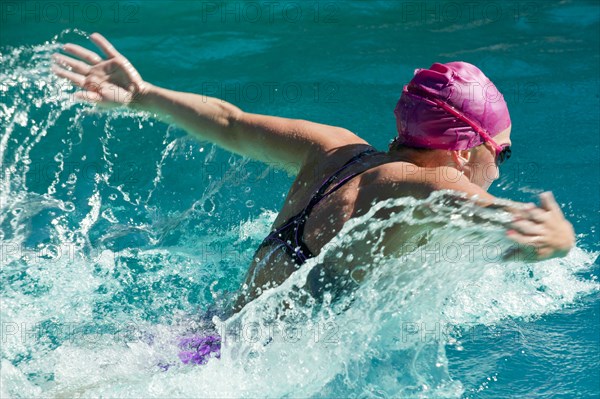 Caucasian teenager swimming in swimming pool