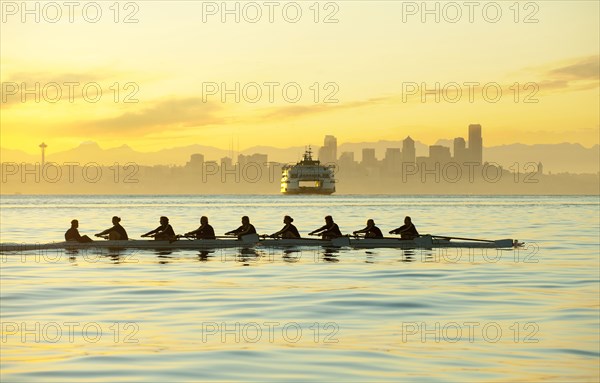 Team rowing boat in bay