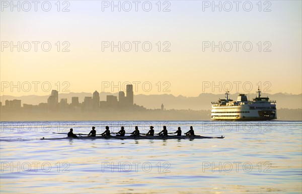 Team rowing boat in bay