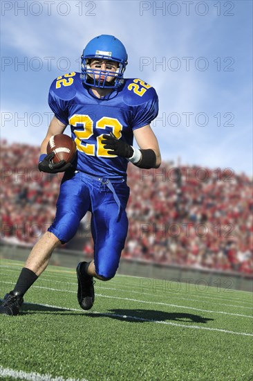 Caucasian football player running with ball