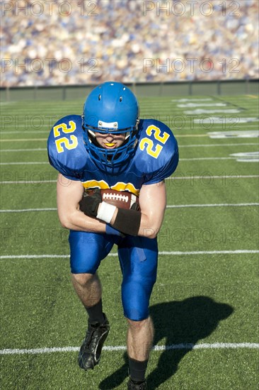 Caucasian football player running with ball