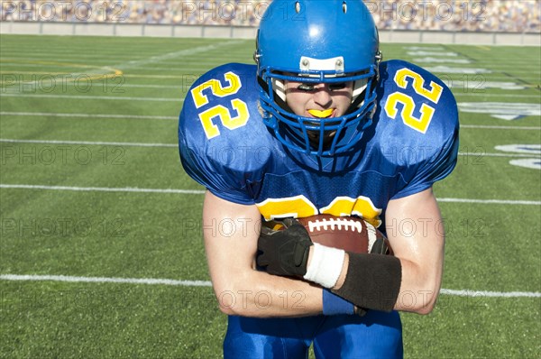 Caucasian football player running with ball